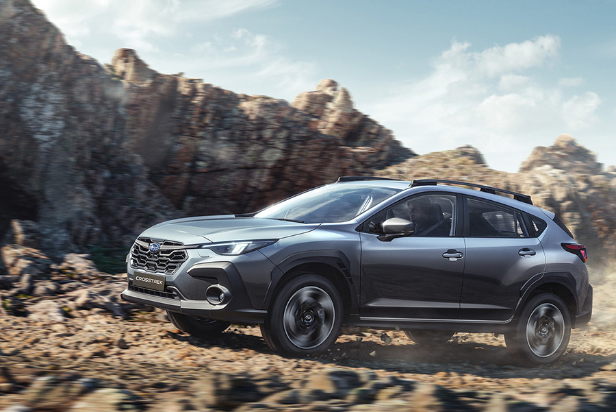 Subaru Crosstrek ajaa soratiellä, pölypilvet nousevat auton takana.