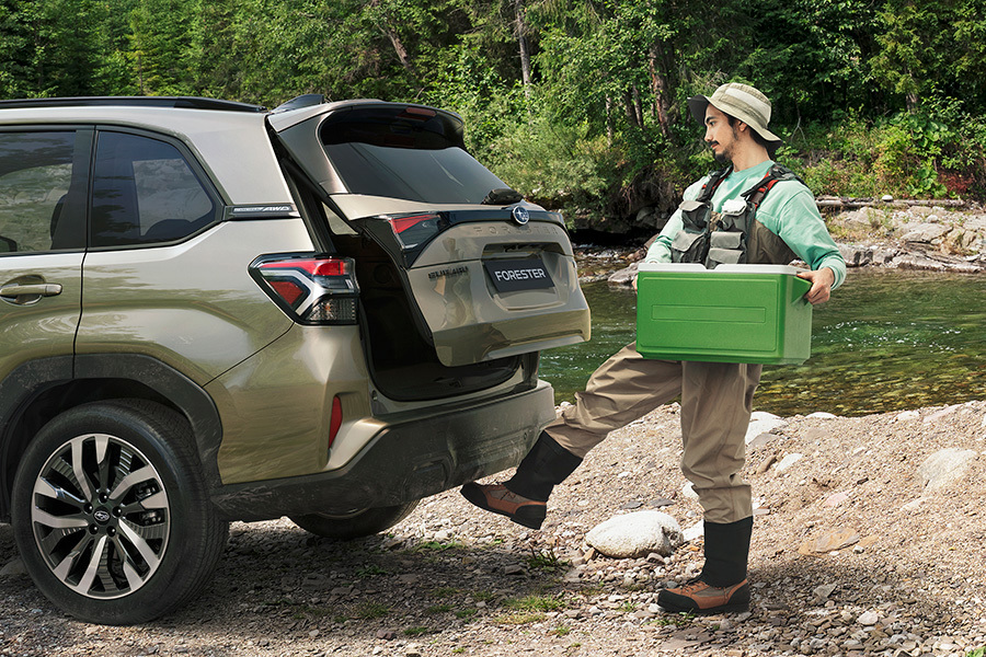 Subaru handsfree-takaluukun avauksella – kalastusvarusteissa oleva mies aktivoi sensorin jalalla saadakseen tavaratilan auki ilman käsiä.